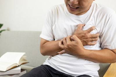 Midsection of man sitting at home