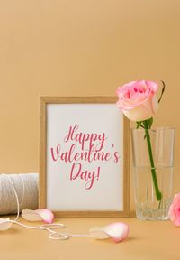 Mockup wooden frame with text happy valentines day on delicate pink roses on beige background