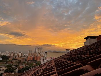 Buildings in city against sky during sunset