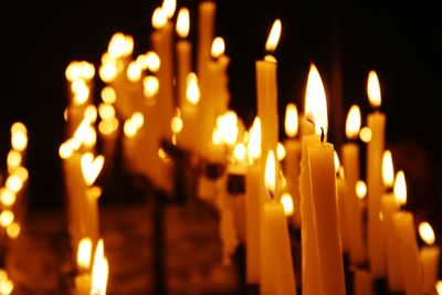 Close-up of lit candles in temple at night