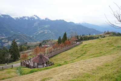 Scenic view of field by mountains against sky