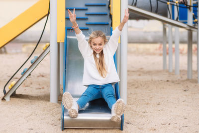 Portrait of girl sliding in playground