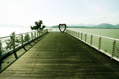 Scenic view of pier on lake against sky