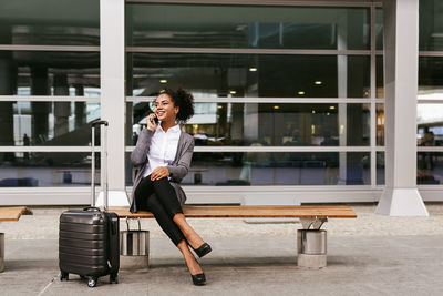 Close-up of businesswoman talking on phone while sitting on bench