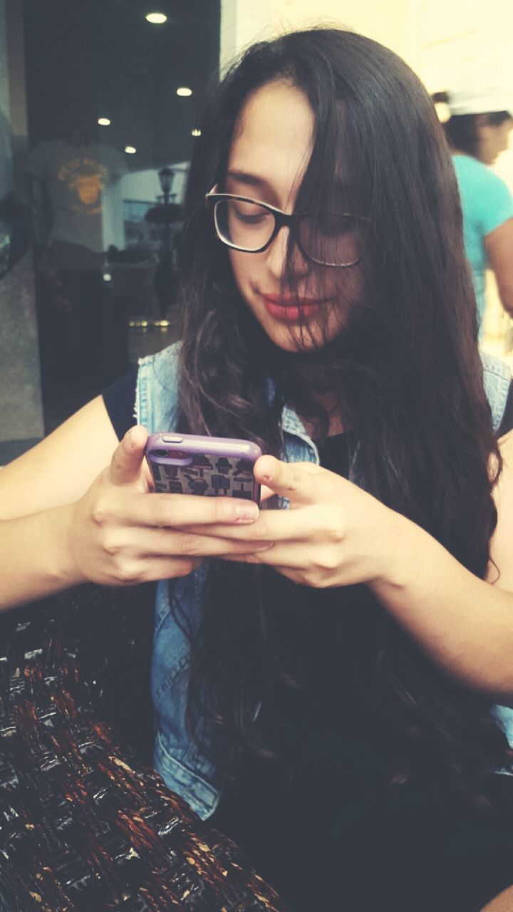 YOUNG WOMAN HOLDING SMART PHONE