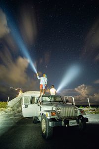 Car on illuminated road against sky at night