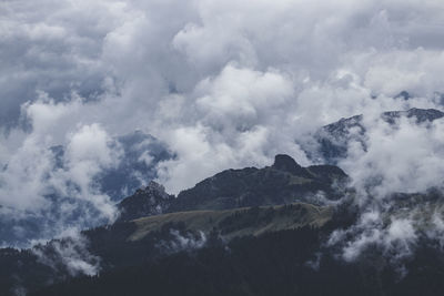 Low angle view of clouds over mountain against sky