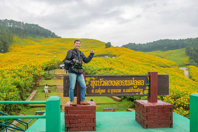 Portrait of man standing by sign board