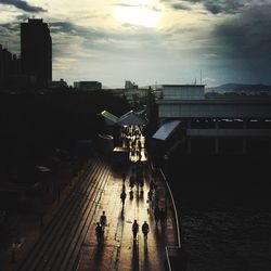 People walking in city against sky