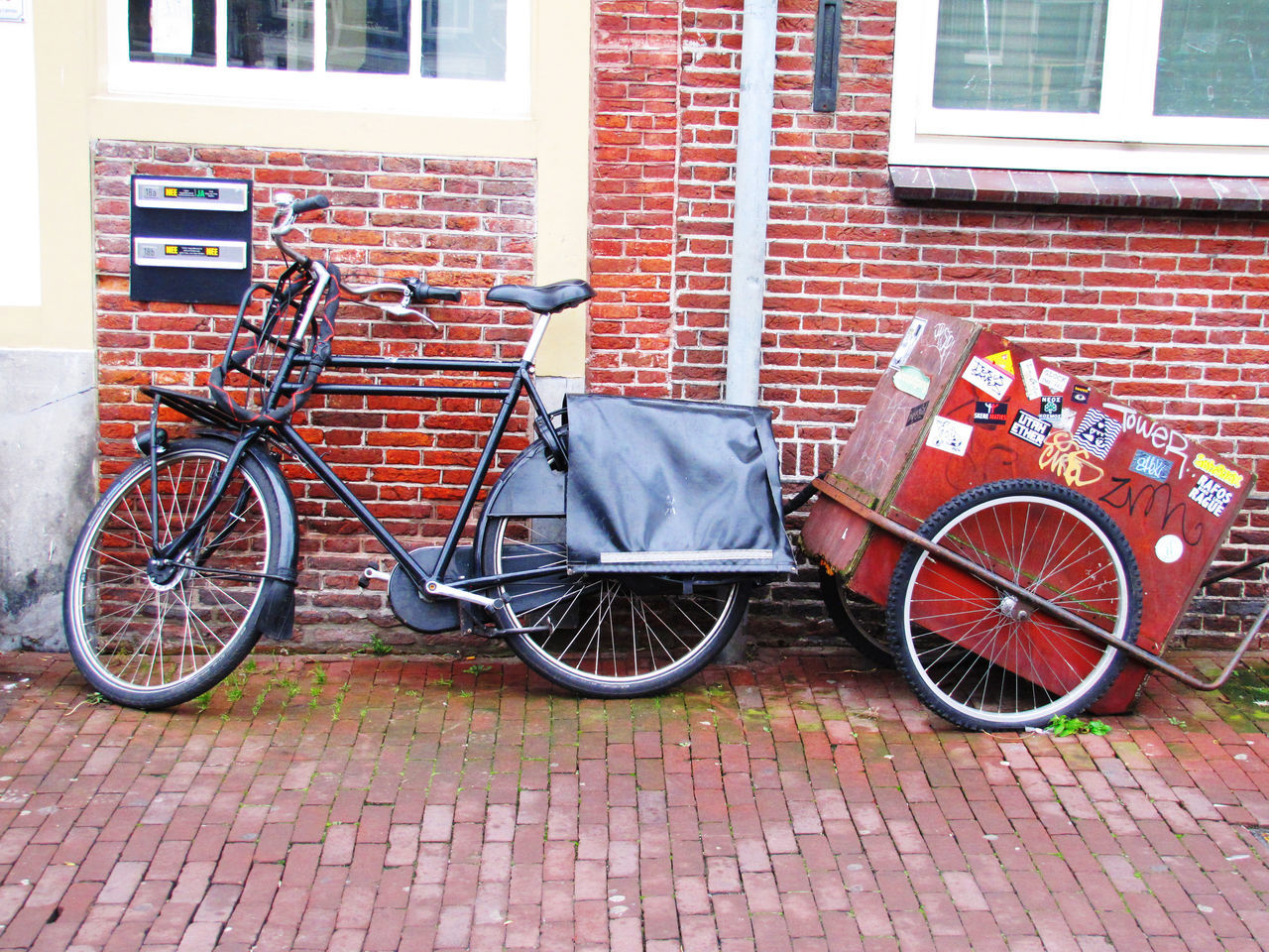 BICYCLE PARKED BY BRICK WALL