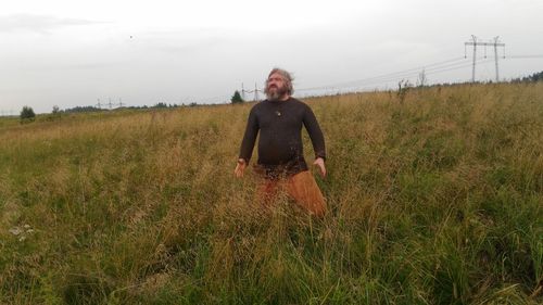 Man standing on field against sky