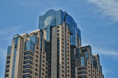 Low angle view of modern buildings against blue sky