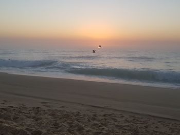 Scenic view of beach against sky during sunset