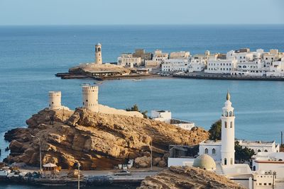 Traditional building by sea against sky