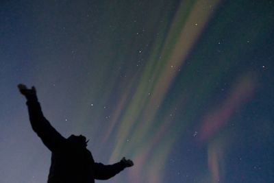 Low angle view of silhouette person against sky at night