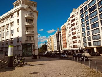 City street by buildings against sky