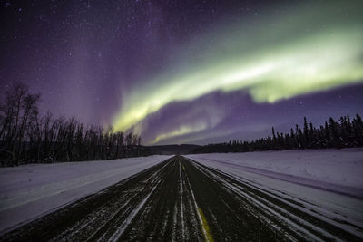 Road against sky at night during winter