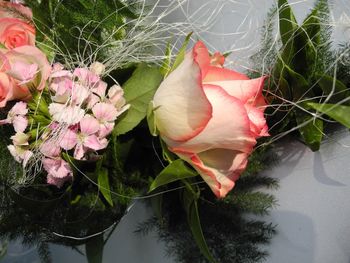 Close-up of rose with pink flowers and leaves in bouquet