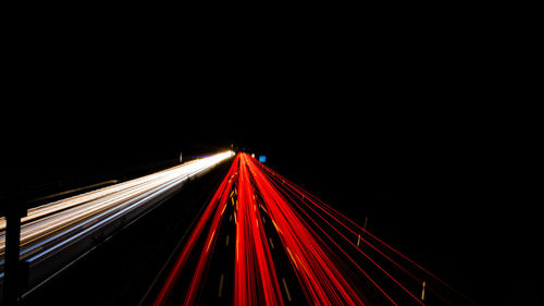 Light trails on road against sky at night