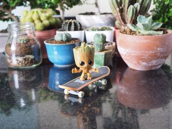 Close-up of figurine with plants on table