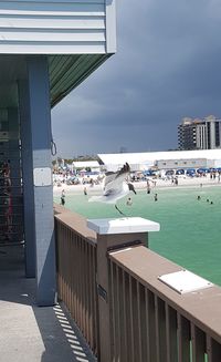 People at beach against sky in city