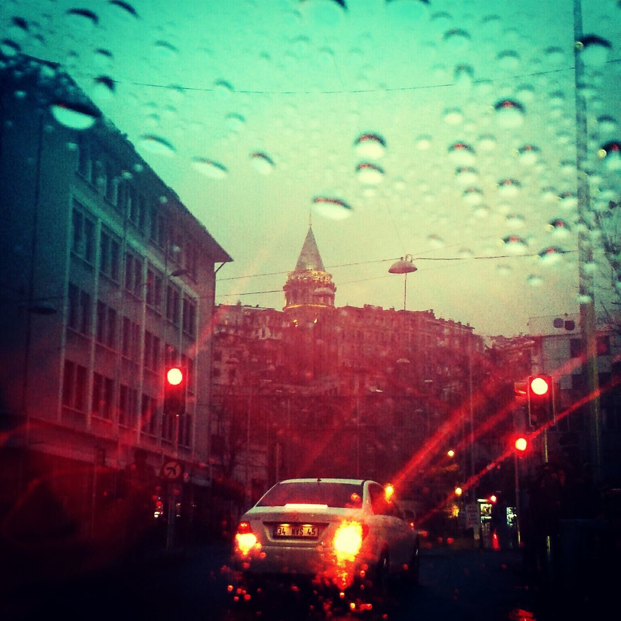 car, transportation, land vehicle, mode of transport, illuminated, architecture, building exterior, street, night, built structure, window, wet, street light, traffic, transparent, city, road, rain, sky, city street