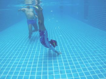 Low section of woman swimming in pool