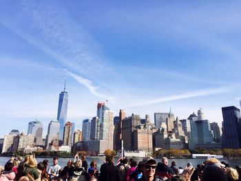 Crowd in city against sky