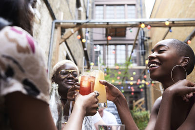 Three friends toasting with cocktails