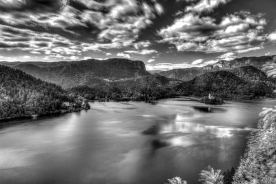 Scenic view of river by mountains against sky