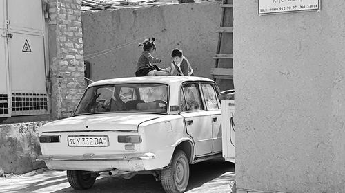 People on street against wall in city