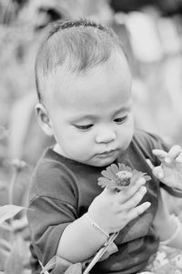 Cute boy holding flower outdoors