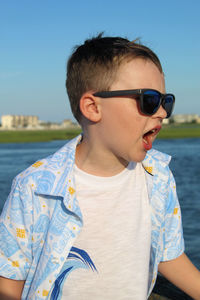 Portrait of boy wearing sunglasses against sky