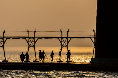 People in silhouette on the grand haven, michigan, pier distorted by heat shimmer off lake michigan