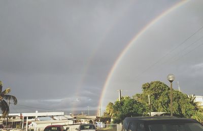 Rainbow over trees against sky
