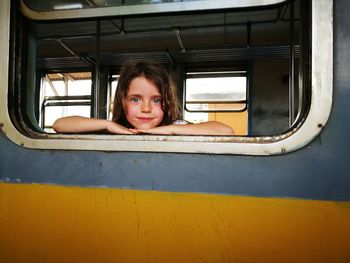 Portrait of girl looking through train's window