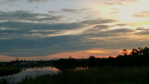 Scenic view of silhouette field against sky during sunset