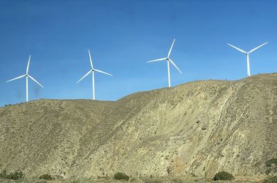 Large rotating wind turbines doting the hills of california, usa