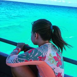 Rear view of girl with sea in background