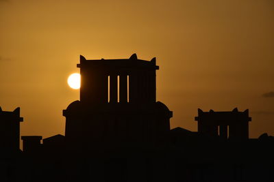 Low angle view of silhouette building against sky during sunset