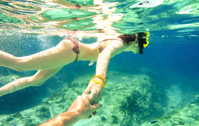 Cropped image of man with woman swimming in sea