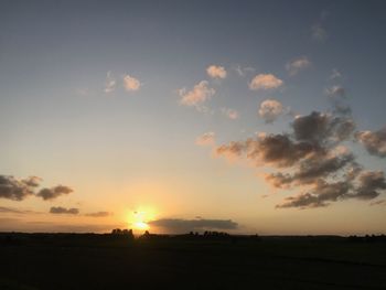 Scenic view of silhouette field against sky during sunset