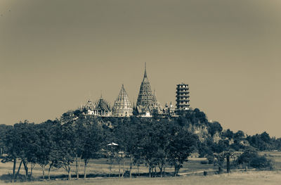 View of trees and buildings against clear sky