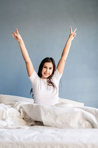 Portrait of smiling young woman lying on bed