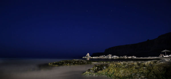 Scenic view of sea against clear sky at night