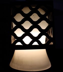 Close-up of illuminated lamp against black background