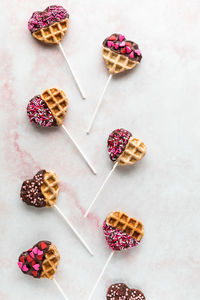Mini valentine decorated waffle pops, against a light background.