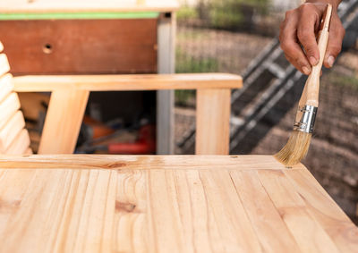 Close-up of person working on wooden plank