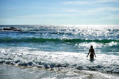 Silhouette woman standing at beach against sky