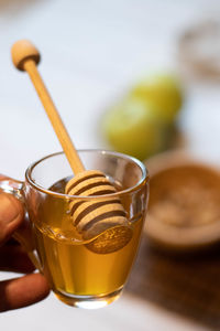 Close-up of hand holding drink on table